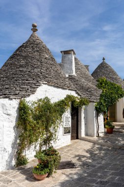 Alberobello, İtalya - 16 Eylül 2019: Trulli köyünde geleneksel beyaz evler. Alberobello, İtalya. Yapım tarzı İtalya 'nın Apulia bölgesindeki Murge bölgesine özgüdür (İtalyan Puglia bölgesinde). Kireç taşı ve temel taştan yapılmış..
