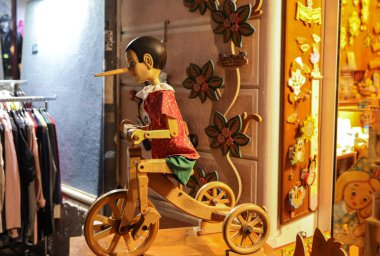 Cesenatico, Emilia Romagna, İtalya - 9 Eylül 2019: Cesenatico 'daki bir hediyelik eşya dükkanında Pinokyo figürünün boyanmış ahşap kuklaları. İtalya. Pinokyo 'nun uzun burnu bir yalanı simgeliyordu..