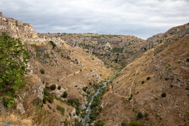 Gravina nehir kanyonu manzarası ve Matera Rupestrian Kiliseleri parkı, antik Matera (Sassi), Basilicata, İtalya yakınlarındaki di Murgia Timone mağaralarında evler.