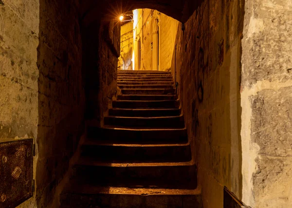 Matera şehrinin tarihi bir bölgesi olan Sassi di Matera 'da bir ara sokaktaki tipik kaldırımlı merdivenler. Basilicata. İtalya