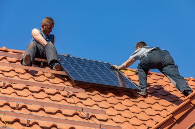 Ochojno, Polonya - 8 Nisan 2020: İşçiler Ochojno 'da bir evin çatısına güneş enerjisi panelleri kuruyorlar. Polonya