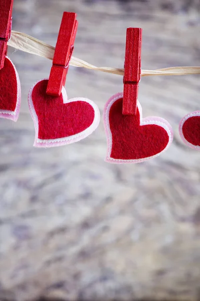 Corazones colgando sobre madera texturizada — Foto de Stock