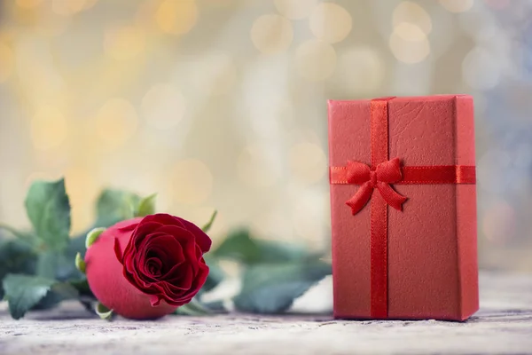 Rote Rose mit Geschenk auf schönem Hintergrund zum Valentinstag — Stockfoto