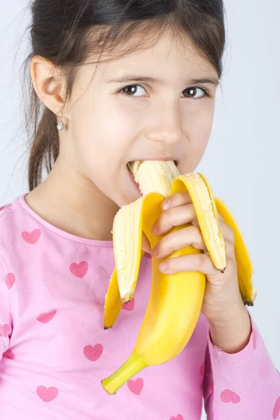 Mädchen isst Banane — Stockfoto