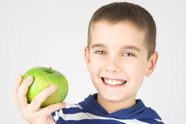 Happy kid smilling and holding fresh green apple — Stock Photo, Image
