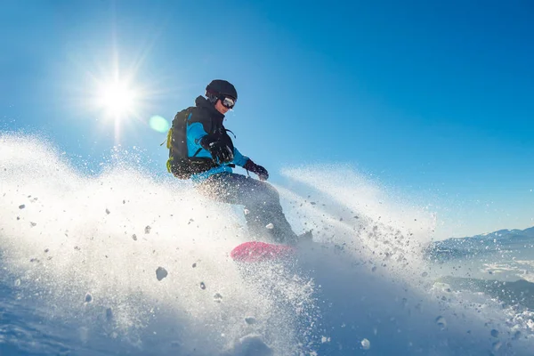 Snowboarder Riding Red Snowboard dans les montagnes à la journée ensoleillée. Snowboard et sports d'hiver — Photo