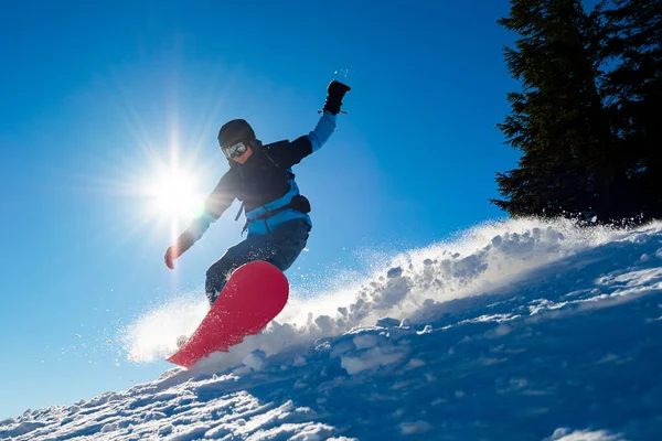 Snowboarder Montar snowboard rojo en las montañas en Sunny Day. Snowboard y deportes de invierno — Foto de Stock