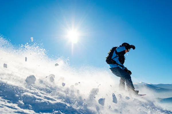 Snowboarder Riding Snowboard dans les montagnes à la journée ensoleillée. Snowboard et sports d'hiver — Photo