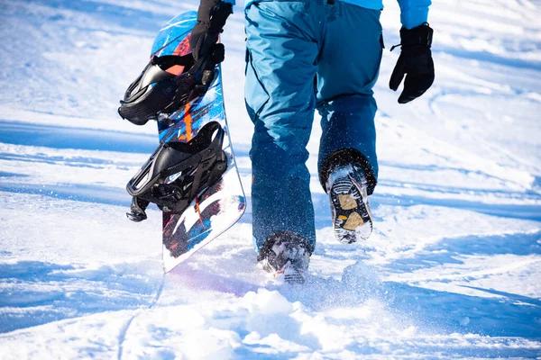 Snowboarder Klimmen met Snowboard in de bergen op zonnige dag. Snowboarden en Wintersport — Stockfoto