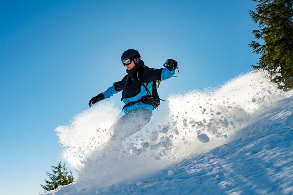 Snowboarder Equitação Snowboard em montanhas no dia ensolarado. Snowboarding e esportes de inverno — Fotografia de Stock