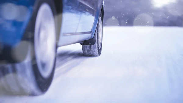 Kék autó gyorsan halad a téli havas úton. Biztonságos vezetési koncepció. — Stock Fotó