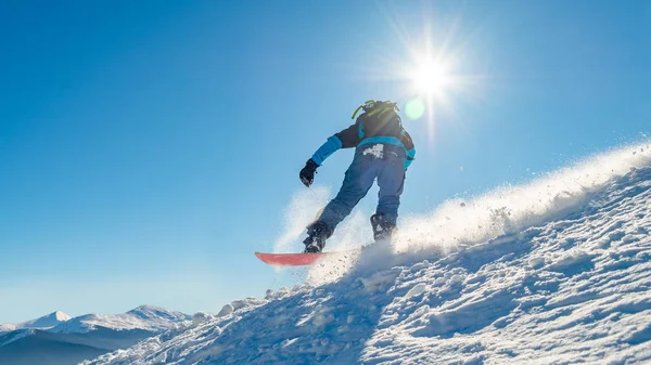 Snowboarder Riding Snowboard dans les montagnes à la journée ensoleillée. Snowboard et sports d'hiver — Photo