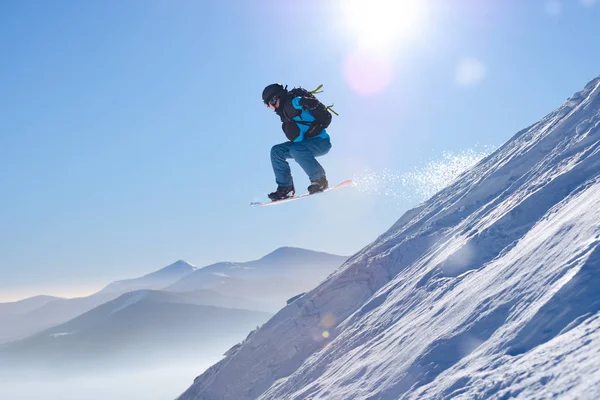 Snowboarder Saut sur le snowboard rouge dans les montagnes à la journée ensoleillée. Snowboard et sports d'hiver — Photo