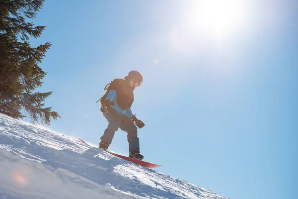 Snowboarder Riding Snowboard dans les montagnes à la journée ensoleillée. Snowboard et sports d'hiver — Photo