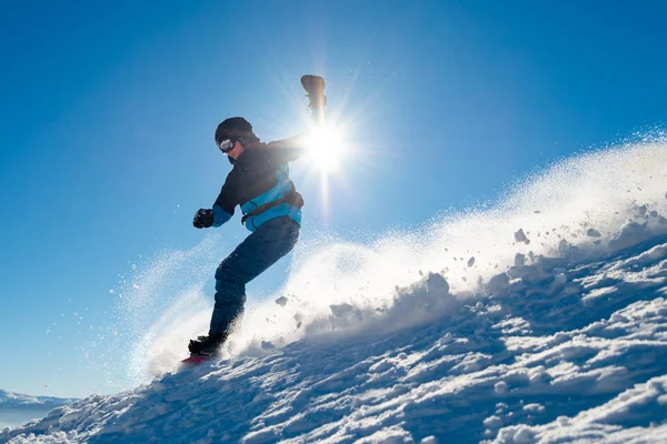 Snowboarder Equitação Snowboard em montanhas no dia ensolarado. Snowboarding e esportes de inverno — Fotografia de Stock