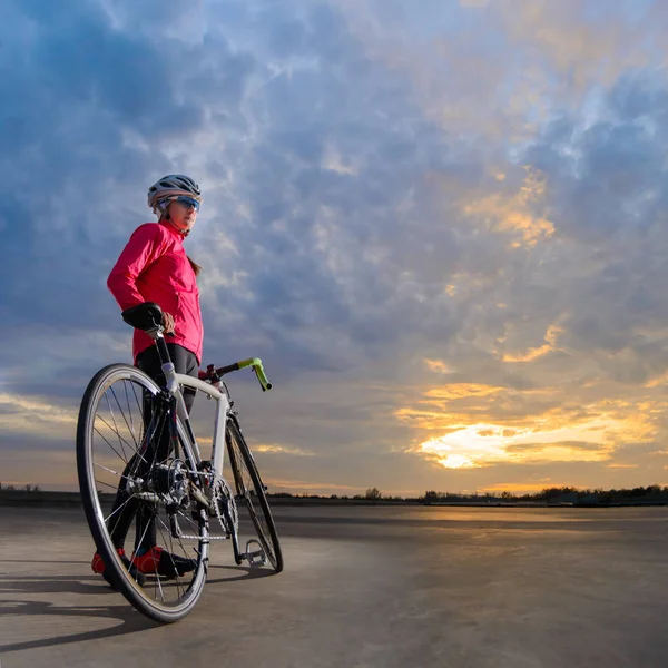 Porträt einer jungen Radfahrerin mit Rennrad bei Sonnenuntergang. gesunder Lebensstil und Outdoor-Sportkonzept — Stockfoto