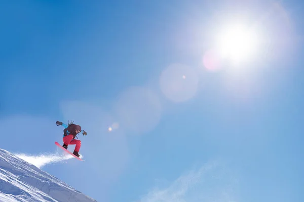 Snowboarder Jumping High op Snowboard in Mountains op zonnige dag. Snowboarden en Wintersport — Stockfoto