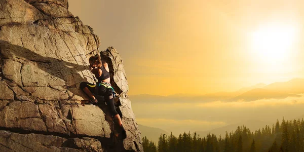 Mooie vrouw klimmen op de rots bij Foggy Sunset in de bergen. Avontuur en extreme sport concept — Stockfoto