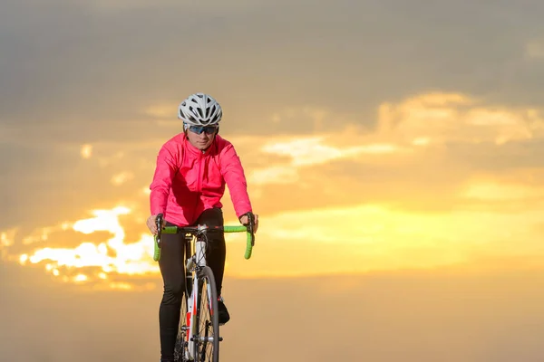 Young Woman Cyclist Riding Road Bike at Sunset. Healthy Lifestyle and Outdoor Sport Concept — 스톡 사진