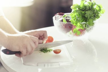 Aşçı Yeşiller beyaz bir tabloda bir bıçakla keser.