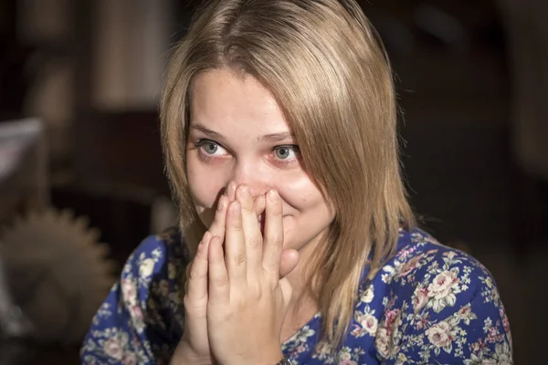 Surprised young woman covering her mouth with hands