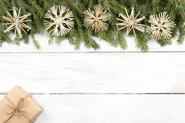 Christmas composition. New Years decor. Branches of pine and christmas presents and decorations on a white old wooden table.