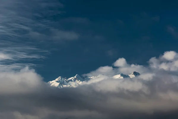 Mountains peaks breaking through the solid cloud bank — Stock Photo, Image