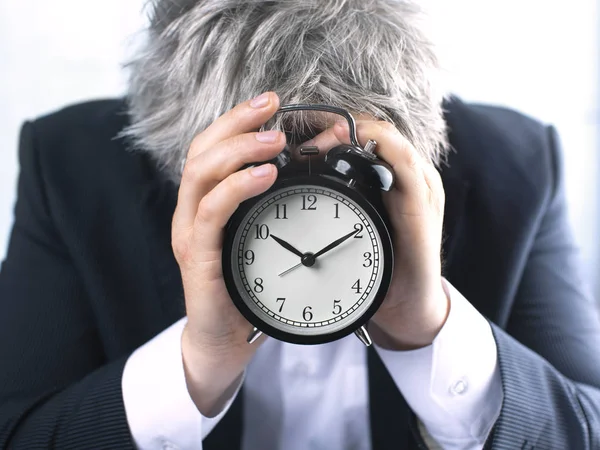 Zakenman bedekking gezicht met klok. — Stockfoto