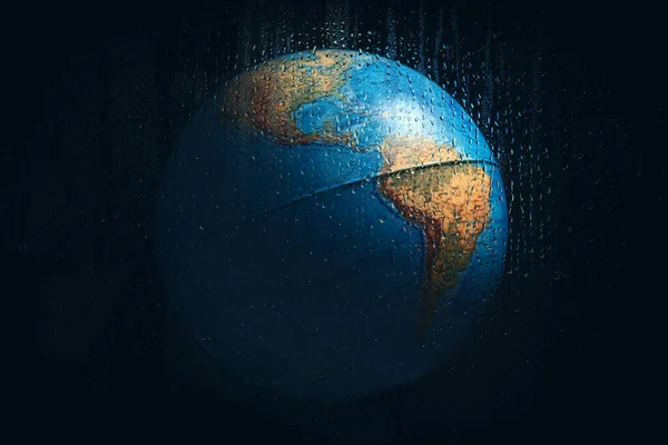 用水滴通过湿玻璃拍摄的行星地球的横向照片 验尸官大流行病后的天气或隔离的概念 — 图库照片