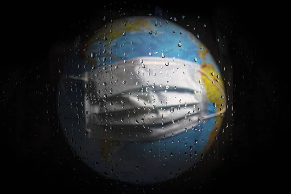 用水滴通过湿玻璃拍摄的行星地球的横向照片 验尸官大流行病后的天气或隔离的概念 — 图库照片