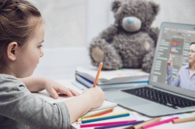 Güzel liseli kız evde online dersi sırasında ödev matematik okuyor, karantina sırasında sosyal uzaklık, kendini izole etme, online eğitim konsepti