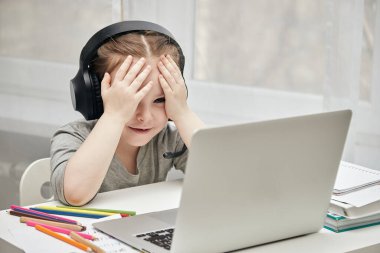 Evde, masada ödev yapan küçük bir kız..