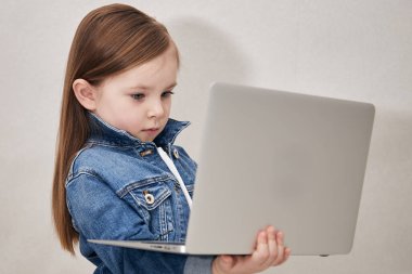 Dizüstü bilgisayar tutan küçük bir kızın portresi