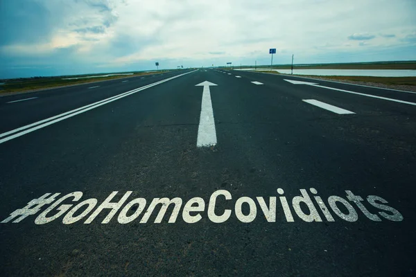 Covidiot è una nuova parola apparsa in connessione con la pandemia globale. La strada con l'hashtag GOHOMECOVIDIOTS — Foto Stock