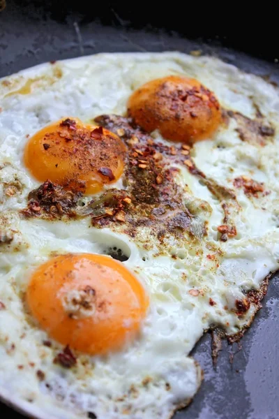 Fried eggs in with red hot chilly pepper — Stock Photo, Image