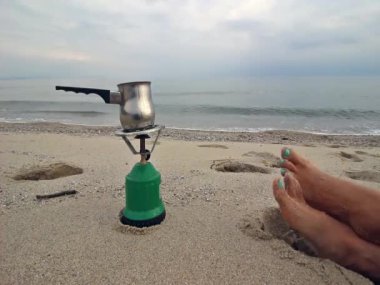     Kadının besleme, sallanan ve rahatlatıcı plaj ve gaz sobası 