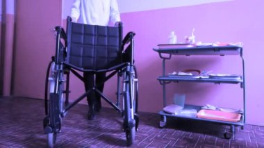     Hemşire ve boş tekerlekli sandalye Park eski hastane, mor filtresi 