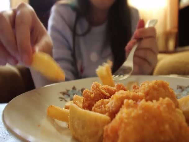 ファーストフードのフライド ポテトと鶏の肉を食べる女子高生クローズ アップ フォーカス ビデオには料理 — ストック動画