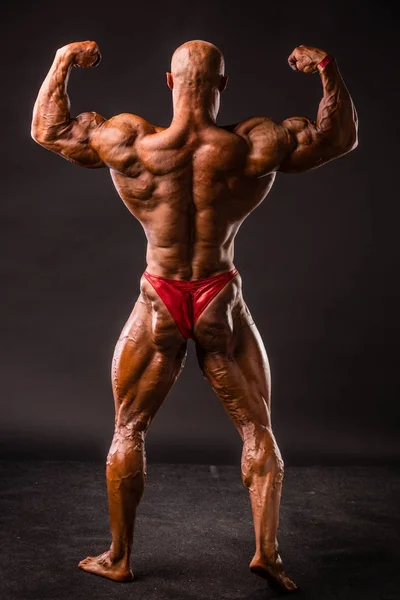 Bodybuilder poseren in studio — Stockfoto