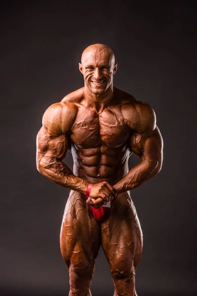 Bodybuilder poseren in studio — Stockfoto