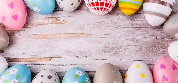 Huevos de Pascua sobre fondo rústico de madera — Foto de Stock