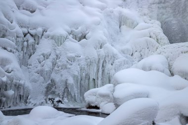 Altai bölgesindeki Pechersk şelalesinden gelen dağ nehrinin buzlu ve karlı kış manzarası