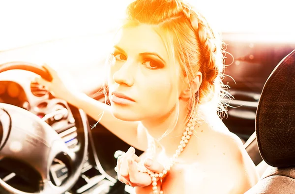 Young Woman in a pearl necklace sat In the drivers seat of her c — Stock Photo, Image