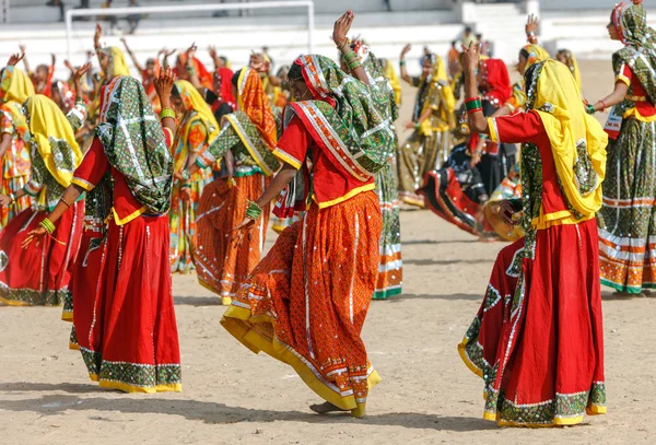 Indian girls in colorful ethnic attire dancing at Pushkar fair, — Stock Photo, Image