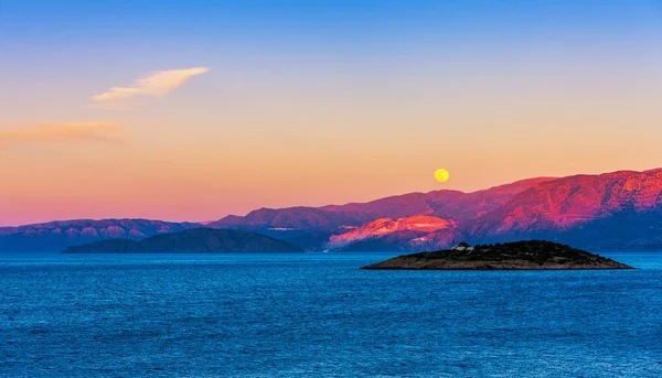 Úplněk nad Krétou při západu slunce — Stock fotografie