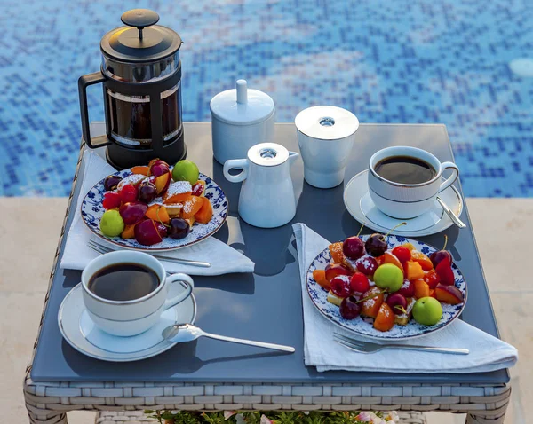 户外游泳池附近有水果和咖啡的餐桌. — 图库照片