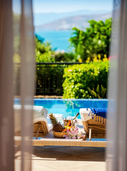 Solstolar Tropiska Frukter Och Champagne Vid Poolen Utsikt Från Fönstret — Stockfoto