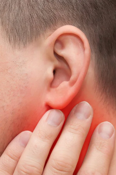 Ear ache. A man holds his hand by the ear
