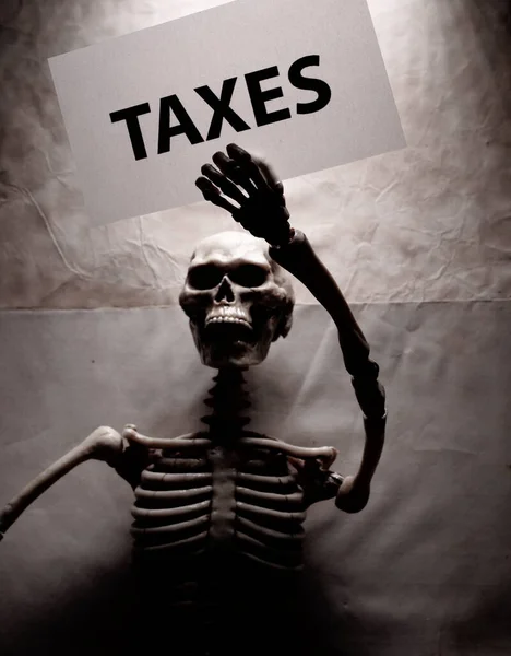 Human Skeleton Holding Tax Label — Stock Photo, Image