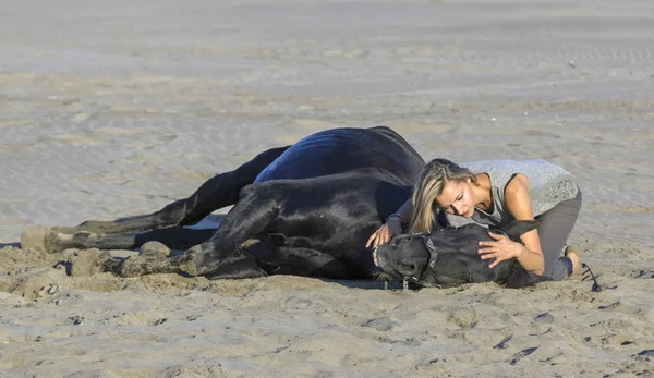 Vrouw en paard op het strand — Stockfoto